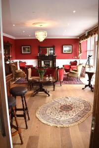 uma sala de estar com paredes vermelhas e uma mesa e cadeiras em Tobervilla Guest House em Caherdaniel