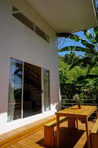 d'une terrasse avec une table en bois et une grande fenêtre. dans l'établissement Villa SOL, à Santa Teresa