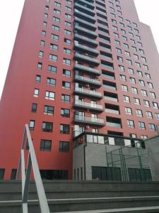 a tall red building with a staircase in front of it at A-Y Apartments P A4 in Tbilisi City