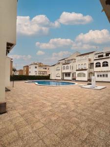 une grande cour avec une piscine en face des bâtiments dans l'établissement Apartment El Paraiso, 1 Bedroom 300M from the sea, à Torrevieja