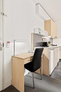 una oficina con un escritorio de madera y una silla negra en 1-Bed in CBD Perfect for a Melbourne City Break, en Melbourne