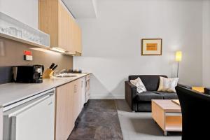 cocina y sala de estar con sofá en 1-Bed in CBD Perfect for a Melbourne City Break, en Melbourne