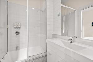 y baño blanco con lavabo y ducha. en 1-Bed in CBD Perfect for a Melbourne City Break en Melbourne