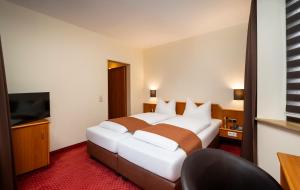 Postel nebo postele na pokoji v ubytování ARKADEN Hotel Kelkheim