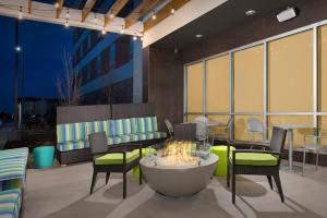 a patio with chairs and a fire pit in a building at Home2 Suites by Hilton Denver International Airport in Denver