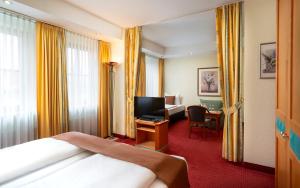 ケルクハイムにあるARKADEN Hotel Kelkheimのベッドとテレビが備わるホテルルームです。