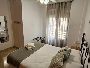 Schlafzimmer mit einem großen Bett und einem Fenster in der Unterkunft Romántico apartamento céntrico in Málaga