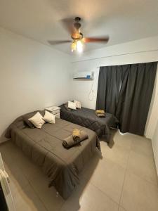 two beds in a room with a ceiling fan at Excelente Departamento Zona Centro Médico B La Cruz in Corrientes