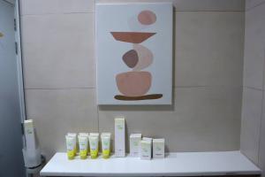 a bathroom with a white counter with a painting on the wall at Warmcloud 2BR Oasis Home in Masdar - Relaxing Stay Near Masdar Park & City Centre in Abu Dhabi +38 photos