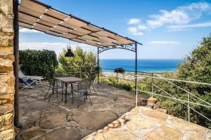 a patio with a table and chairs and the ocean at La Cantina - ACrapa Mangia in Santa Maria di Castellabate
