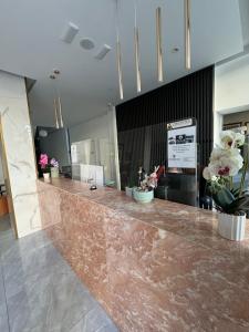 a lobby with a marble counter with potted plants at Catherine Hotel in Kos Town