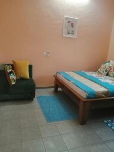 um quarto com uma cama e um sofá em Bertoua : Bel appartement en centre-ville em Bertoua