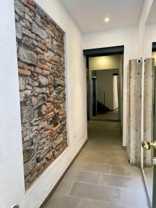 um quarto com uma parede de pedra e um corredor em ATENA Lake Como em Como