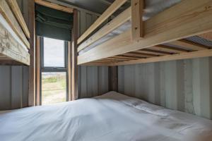雅茅斯1 Swallows Nest, Camp Tapnell的一间卧室，有两张双层床和一扇窗户