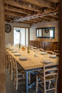 a long table with chairs and a large table with glasses at Chalet montagnard rénové avec jacuzzi 4****- 15 Personnes in Saint-Sorlin-dʼArves