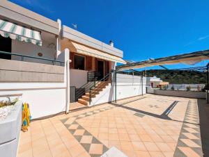 eine Terrasse eines Hauses mit Markise und Treppe in der Unterkunft Oikia Vacanze S Cesarea Casa Rosa su in Santa Cesarea Terme