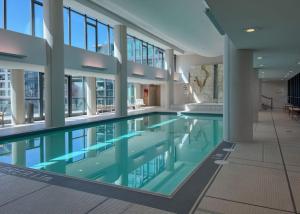 a swimming pool in a building with glass windows at 2 BR with Amazing city views & Free parking in Toronto