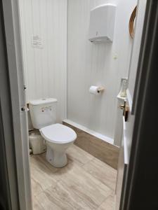 uma casa de banho branca com um WC e um chuveiro em Fairhaven Guest Accommodation em Nottingham