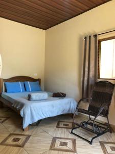 a bedroom with a bed and a chair in it at Refúgio Encantado in Eldorado