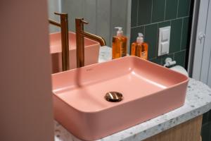 ein rosa Waschbecken auf der Theke im Bad in der Unterkunft Hacienda Grunwaldzka Bydgoszcz in Bydgoszcz