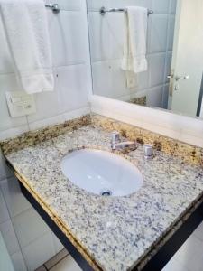 a bathroom sink with a granite counter top at The Palace Flat Moema in Sao Paulo