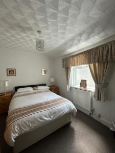 紹斯波特的住宿－Bayona Guest House，一间卧室设有一张带格子天花板的床。
