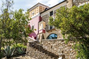 a house with a stone wall and stairs at La Rimessa - ACrapa Mangia in Santa Maria di Castellabate