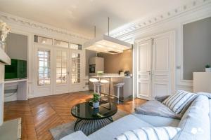 ein Wohnzimmer mit einem Sofa und einem Tisch in der Unterkunft MBA - Luxury Berthier Proche des Ternes in Paris