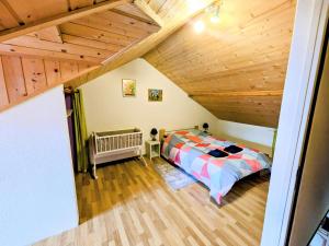 1 dormitorio con cama y techo de madera en appart proche de la frontière, en Les Gras