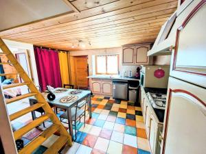 a kitchen with a table and a staircase in it at appart proche de la nature in Les Gras