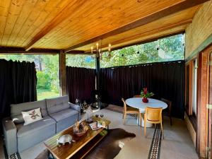 a living room with a couch and a table at Pousada Chalés Jardim das Bromélias - Visconde de Mauá in Visconde De Maua