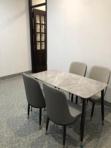 uma mesa com quatro cadeiras e uma tampa de mármore branco em Hidden gem homestay 2 em Hanói