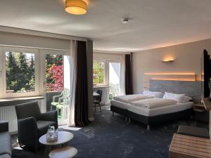 1 dormitorio con 1 cama y sala de estar en Hotel Haus am Hochwald, en Hahnenklee-Bockswiese