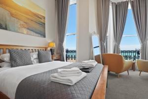 Una habitación de hotel con una cama con toallas. en Beach Front Guest House en Eastbourne
