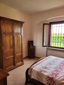 1 dormitorio con 1 cama, vestidor y ventana en La Vecchia Riseria 1, en Novara