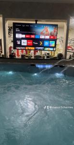 a tv sitting on top of a pool of water at MANOIR AUX trois charmes in Ronchamp