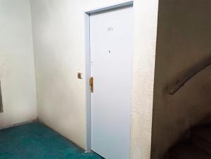 uma porta branca num quarto com piso verde em GARCIA INN MZA con desayuno seco em Mendoza