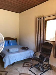 1 dormitorio con 1 cama, 1 silla y 1 ventana en Refúgio Encantado en Eldorado