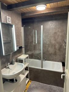 La salle de bains est pourvue d'un lavabo et d'une baignoire. dans l'établissement Appartement Duplex Les Bleuets K10, à Val dʼIlliez