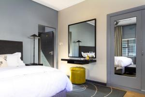 een slaapkamer met een bed en een grote spiegel bij Life & Leisure Boutique Guesthouse in Stellenbosch