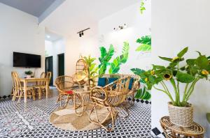 a living room with chairs and tables and plants at Vy Apartment- New Life Ha Long in Ha Long