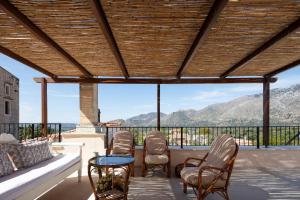 a patio with chairs and a table with a view at Captain's Hyatt in Garazo