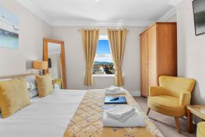 伊斯特布恩的住宿－聖奧馬爾酒店，卧室配有床、椅子和窗户。