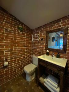 a brick bathroom with a toilet and a sink at Curtea Domneasca in Cricova +34 photos