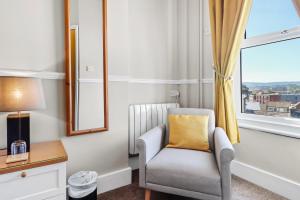 sala de estar con silla y ventana en Beach Front Guest House, en Eastbourne