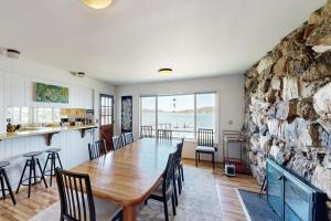 a dining room with a table and a stone wall at Davis House on the Bay in Lopez