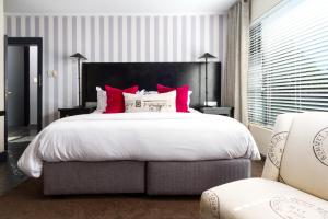 a bedroom with a large bed with red pillows at Life & Leisure Boutique Guesthouse in Stellenbosch