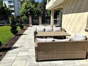 patio z drewnianym stołem i wiklinowymi meblami w obiekcie Villa Moste 3-Free parking&pool w Lublanie