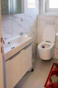斯盧尼的住宿－Apartman Milka，白色的浴室设有卫生间和水槽。