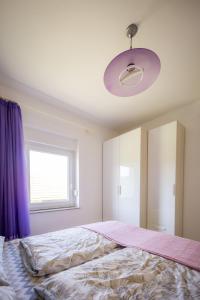 斯盧尼的住宿－Apartman Milka，一间卧室配有一张带紫色窗帘的大床